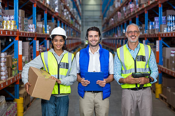 smiling-group-of-workers-looking-at-camera-in-warehouse