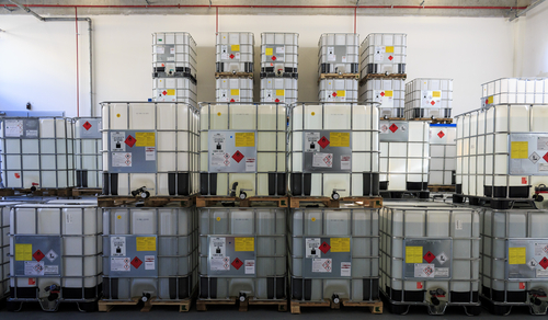 IBC Containers with highly flammable chemical liquids in warehouse. Containers have ADR symbols of 3rd. category on it