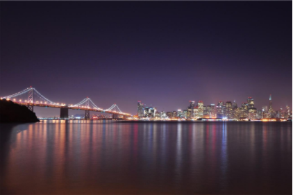city and bridge on shoreline at night