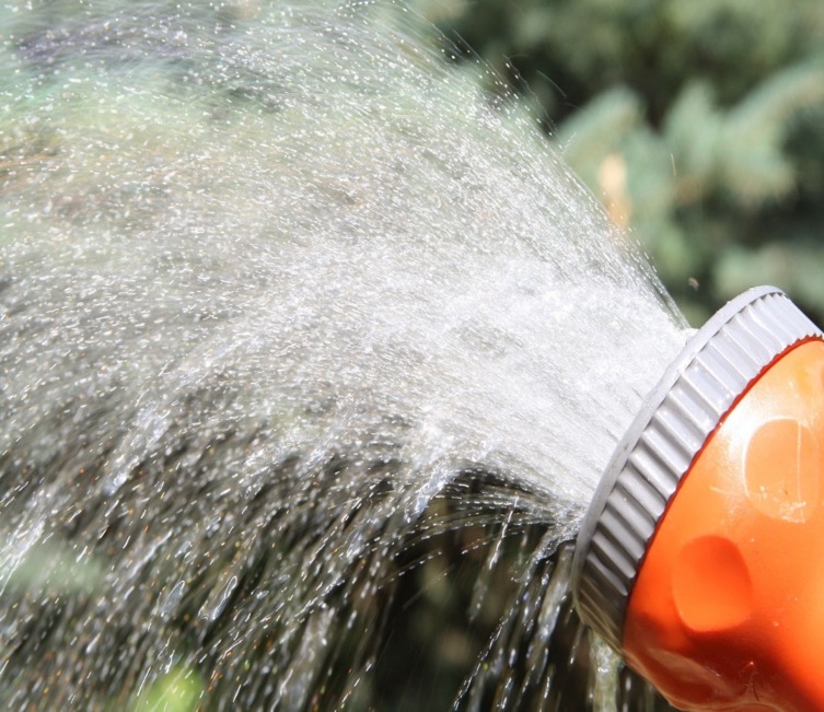 closeup of orange garden spigot on hose