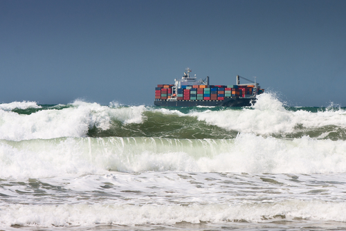 freight ship with shipping containers on rough sea