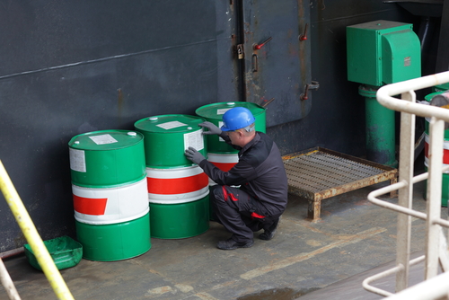 Industrial worker inspecting barrels in industrial plant