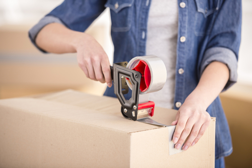 woman packing box with tape