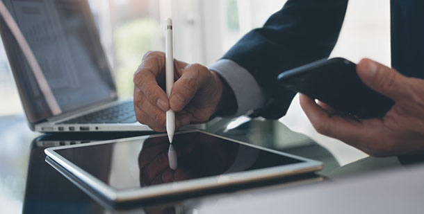 man using stylus to sign tablet