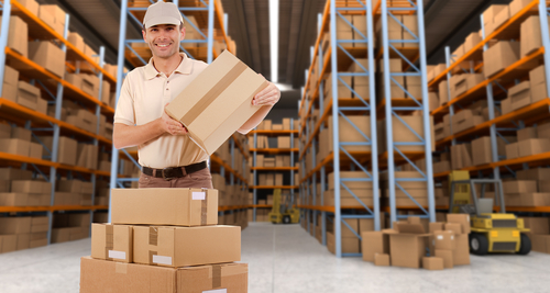 Deliveryman carrying a parcel in a distribution warehouse