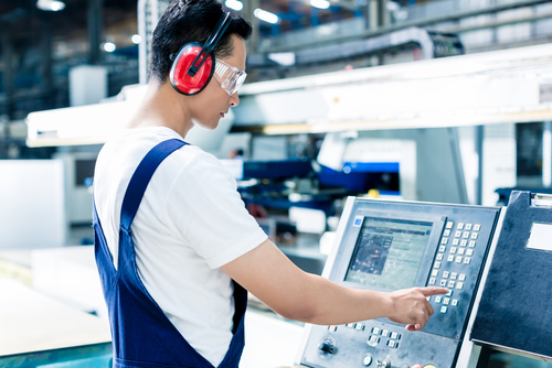 technician entering data factory machine