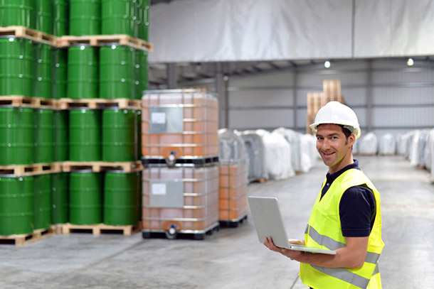 worker in a warehouse with oil barrels
