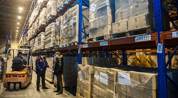 warehouse workers in aisle with shipping boxes