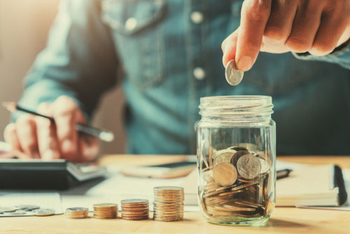 dropping coin into jar