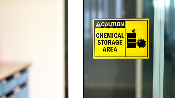 Black-yellow Chemical storage area Hazard Sign and symbol on the glass door, Caution for warning dangerous space in laboratory room. selective focus on tag, blurred background Safety first concept.