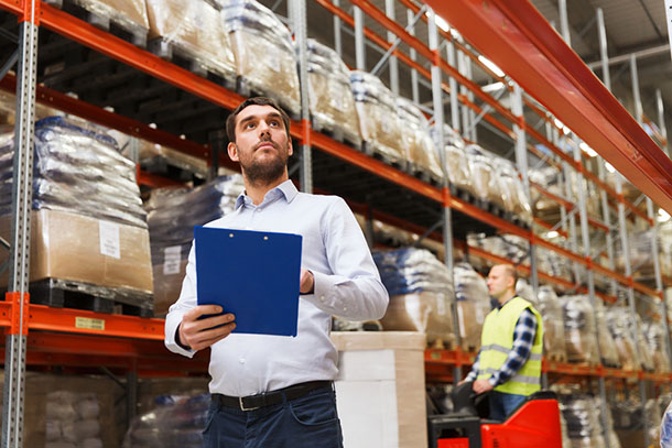 A man doing checks on stock in a warehouse