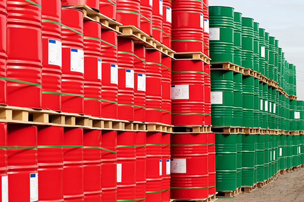 a grouping of stacked red and green chemical drums