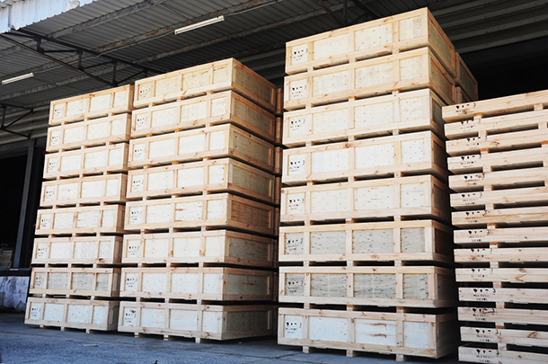 several stacks of cargo in wooden cases at a warehouse