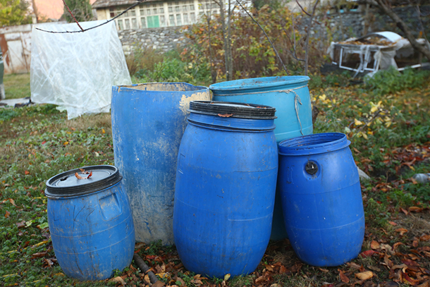 a group of blue plastic barrels for chemical storage