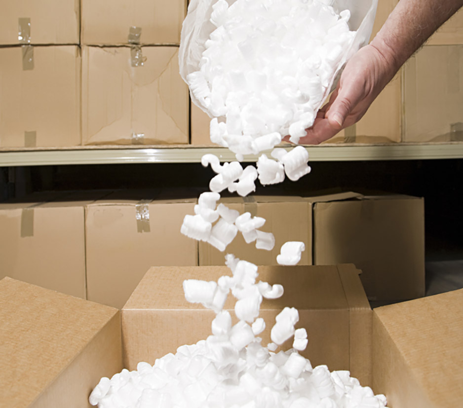 person putting packing peanuts in a box